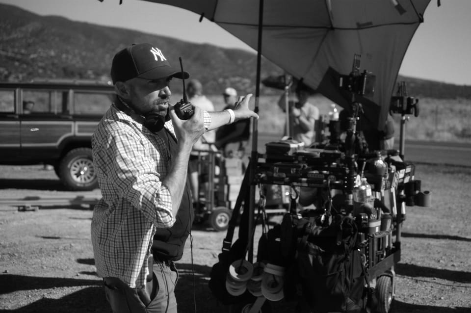 A director speaks into a walkie on a film set of Faith of Angels